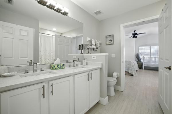 Fully renovated guest bathroom with dual sinks and shower tub combo accessible from king bedroom and hallway at Pinnacle, Unit 2503 Naples FL