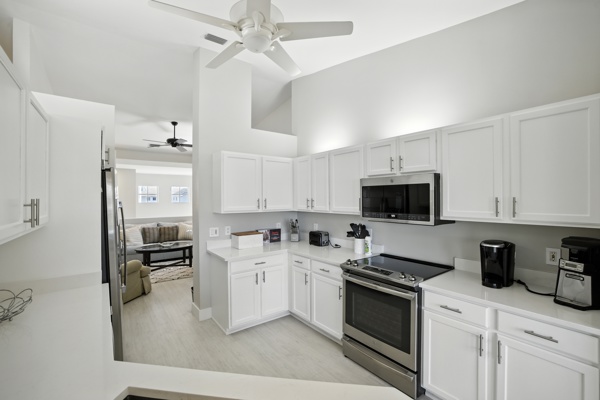 Kitchen with view into bonus room featuring pull-out couch and private office area at Pinnacle, Unit 2503 Naples FL