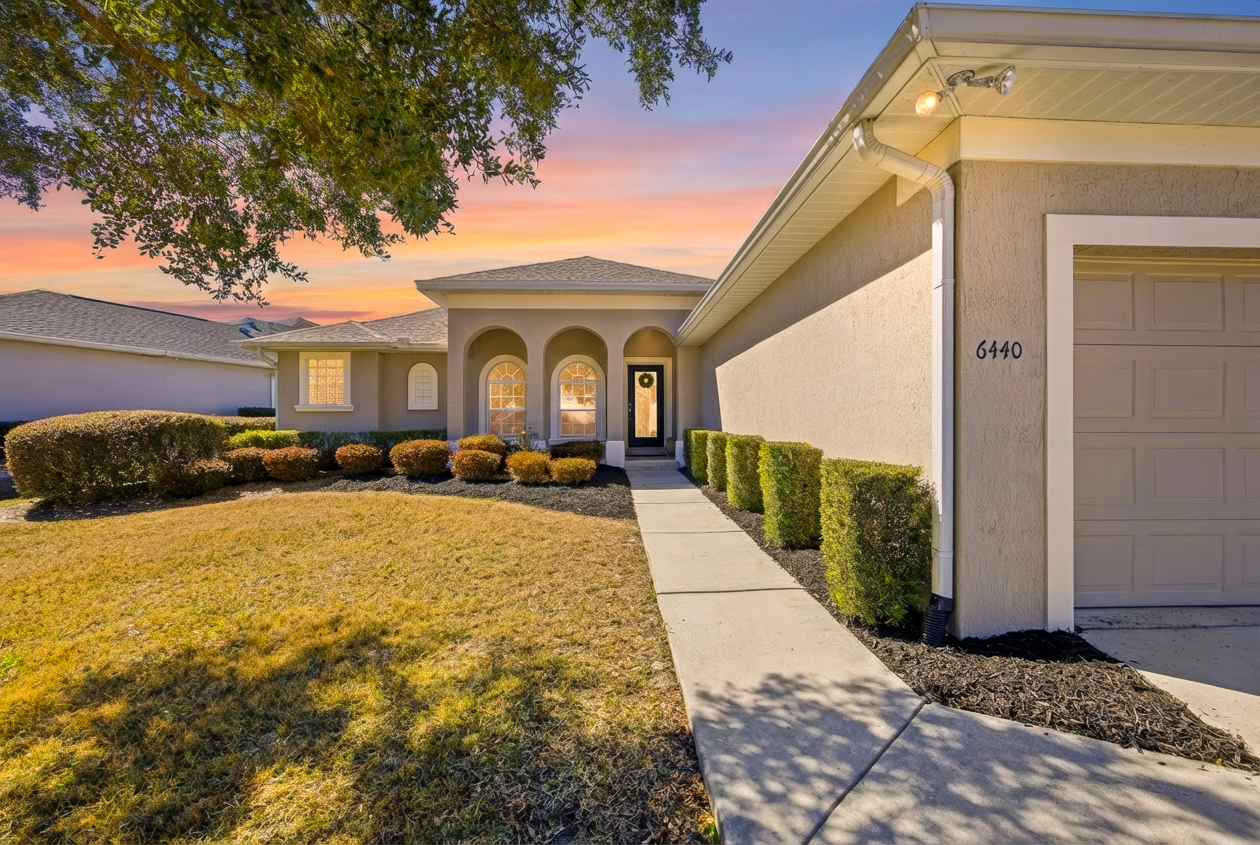 6440 SW 50th Terr, Ocala FL, front exterior at sunset in Heath Brook Hills