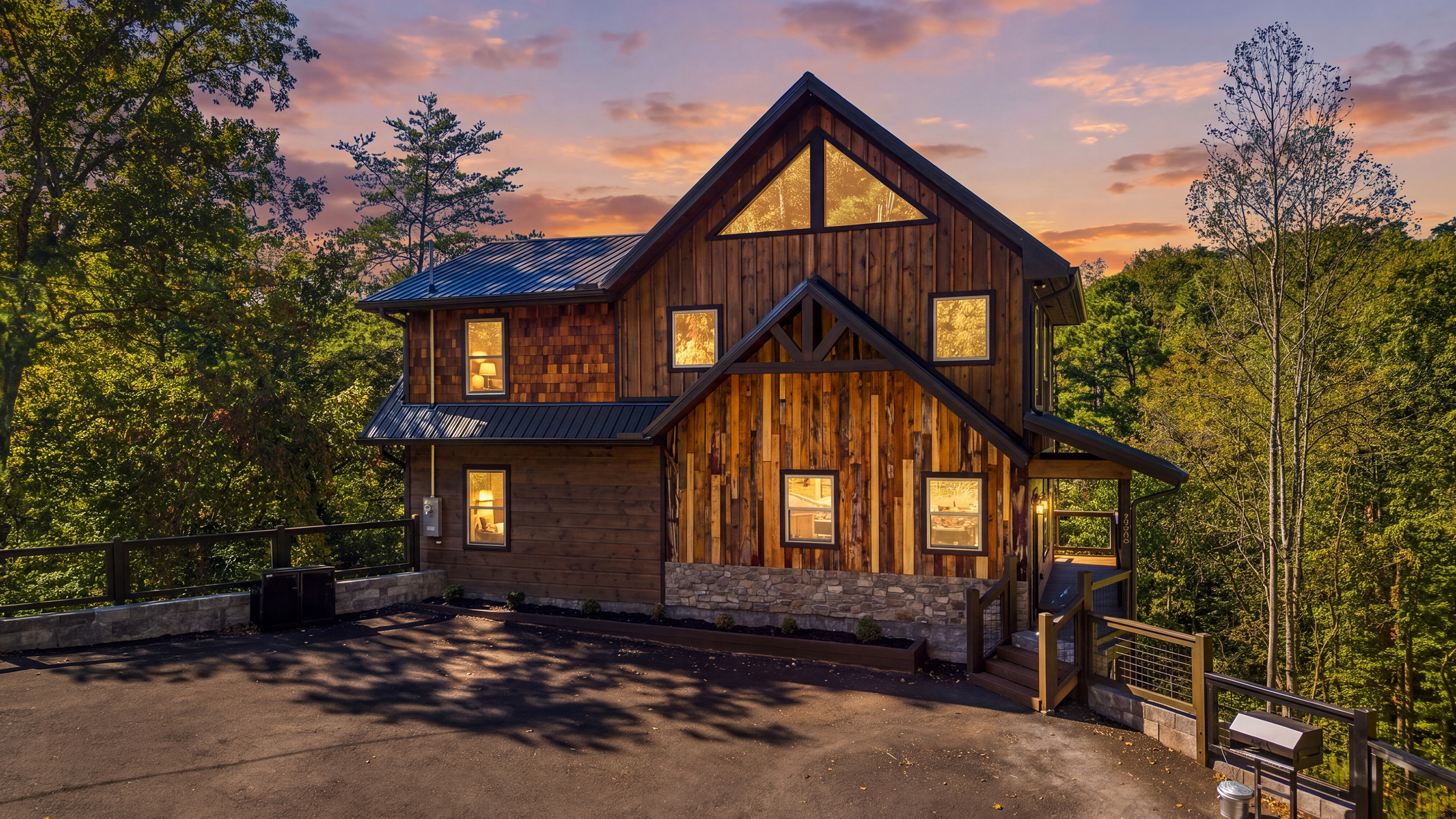 A timber cabin with warm windows beneath a colorful evening sky in Sevierville.