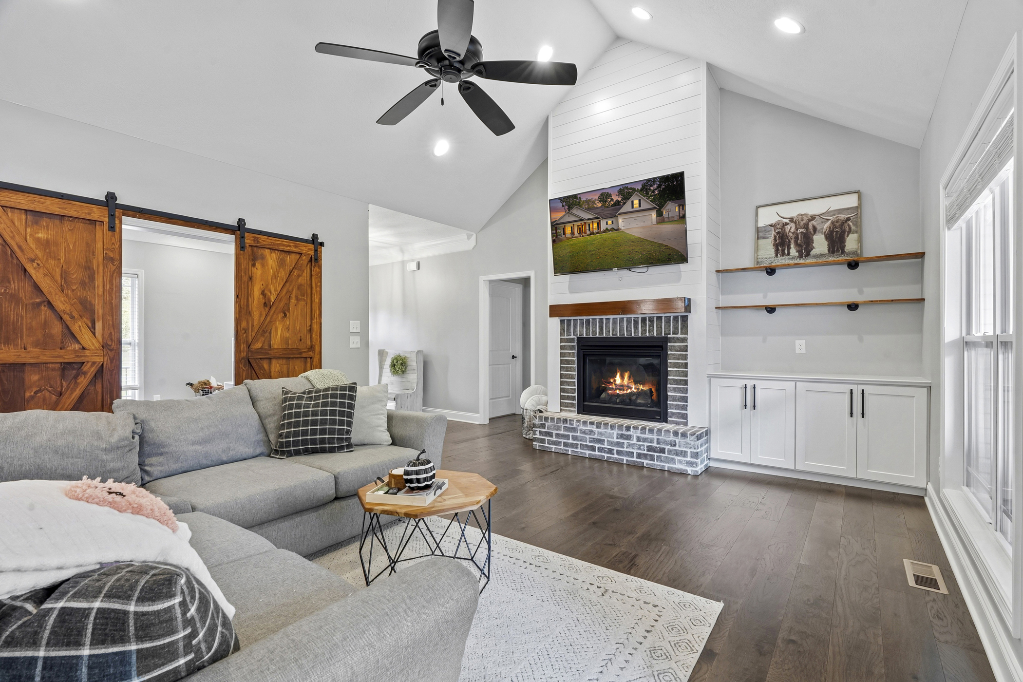 A bright living room with a fireplace, built-in cabinetry and wood sliding doors.