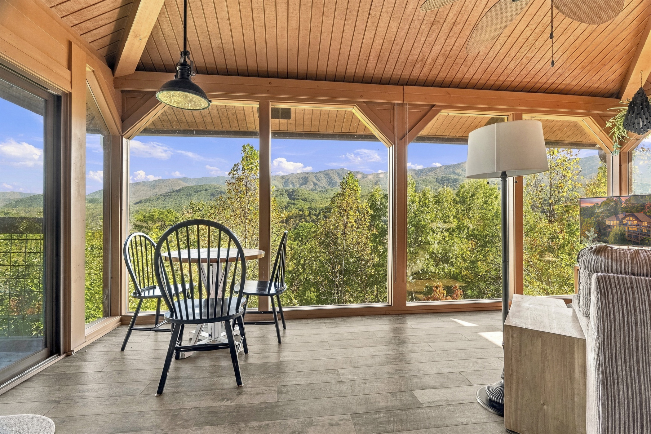 Bright timber sunroom framing sweeping Smoky Mountain views through floor-to-ceiling windows.
